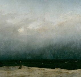 A figure stands on a cliff face, looking out across a stormy sea.