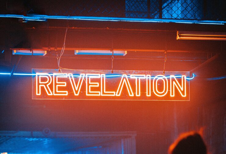 a neon sign reads revelation in red