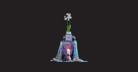 an altarcloth of Indigenous fabris lies across a table. On top are orchids and an icon. On the floor below are a cross and lit candle